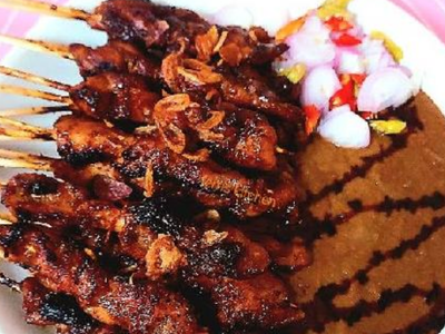 Indonesian Satay skewers with peanut sauce and rice cakes